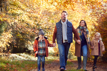 Family With Mature Parents And Two Children Holding Hands Walking Along Track In Autumn Countryside / Photodune, Misc