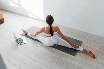 With laptop. Young caucasian woman with slim body shape is indoors at daytime / Photodune, Misc