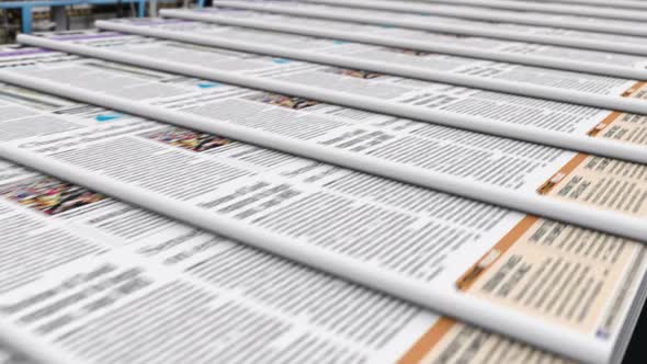 Newspapers with Latest News Release on a Conveyor Belt in the Editorial Office