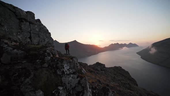 Hiker Climbing Down Mountainside At Sunrise