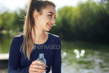 公園で青いスポーツウェア飲料水を身に着けている若い美しい女性の肖像画 / Photodune, Misc