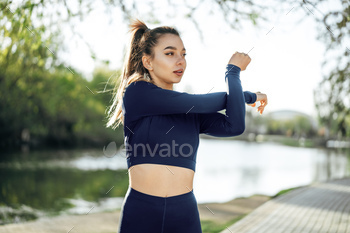 Fit young girl in dark blue sportswear exercising in park / Photodune, Misc
