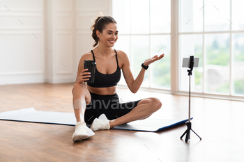 Young woman recording video blog on smartphone / Photodune, Misc
