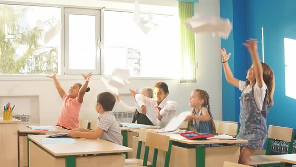 School Kids Have Fun in Class and Throwing Paper in Air