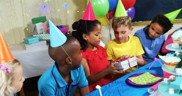 Friends giving gift box to girl during birthday party 4k