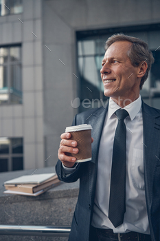Handsome businessman drinking coffee on the street / Photodune, Misc