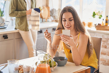 Positive delighted longhaired brunette reading news online / Photodune, Misc