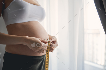 Tummy at the third trimester near the big window with yellow tape / Photodune, Misc