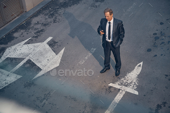Well-dressed businessman using cellphone on the street / Photodune, Misc