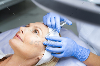Beautiful woman daydreaming during a professional facial / Photodune, Misc