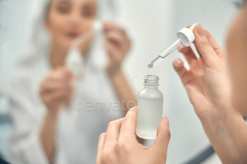 Pretty Caucasian lady holding face care product / Photodune, Misc