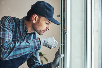 Master's work. Close-up of young handyman setting new windows / Photodune, Misc