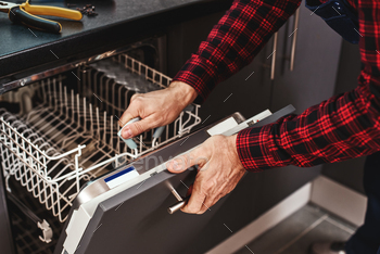 Repairing dishwasher. Close-up of man technician sitting near dishwasher / Photodune, Misc