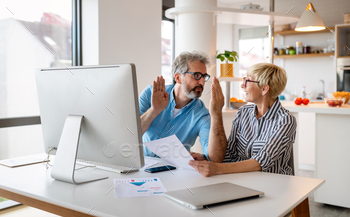 Happy mature business colleagues in modern office using computer and brainstorming / Photodune, Misc