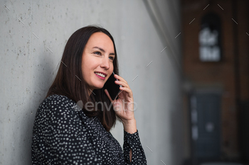 Portrait of mid adult businesswoman standing indoors in office, using smartphone / Photodune, Misc