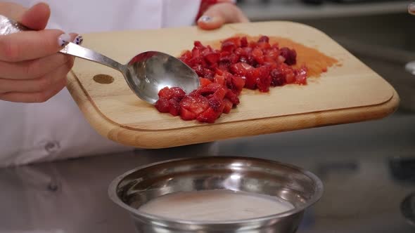 Close-up of a Girl Cook Mixing Fresh Strawberries with Yogurt for Cream.