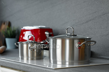 Still life photo of metal casseroles on induction stove in kitchen / Photodune, Misc