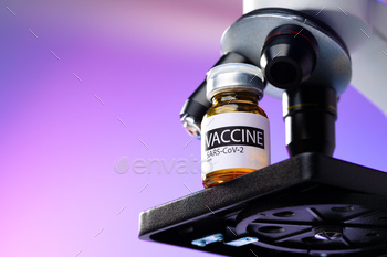 Vial of Covid-19 vaccine next to a microscope / Photodune, Misc