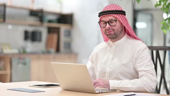 Young Arab Businessman with Laptop Smiling at Camera in Office