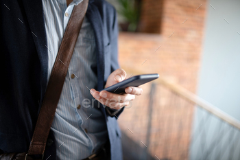 Close up of man wearing shirt and jacket holding smartphone / Photodune, Misc