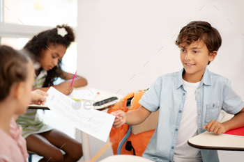 Girl giving her test with answers to her best friend / Photodune, Misc