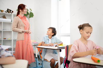 Red-haired teacher answering question of smart dark-haired boy / Photodune, Misc