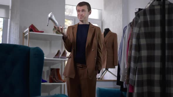 Portrait of Elegant Caucasian Gay Man Throwing Back Silver Shoe in Slow Motion Putting Hands in