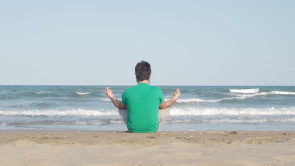 Unrecognizable Man From Behind Meditating or Practicing Yoga at Sea