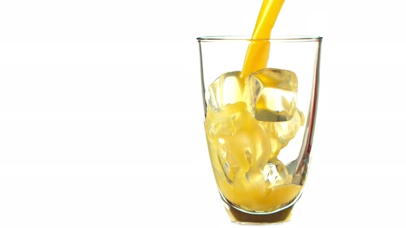 Super Slow Motion Shot of Pouring Fresh Orange Juice Into Glass with Ice Cubes at 1000 Fps