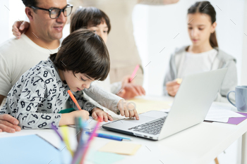 Playing together. Little latin boy looking focused while drawing, spending time with his family at / Photodune, Misc