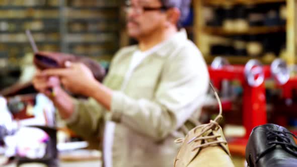 Cobbler examining a shoe