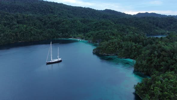 Aerial View Of Triton Bay: Boat On Turquoise Sea And Green Tropical Trees In Kaimana Islands. 