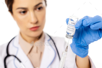 Selective focus of doctor picking up coronavirus vaccine in syringe isolated on white / Photodune, Misc