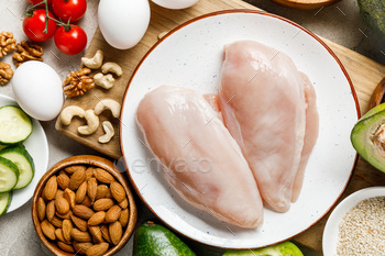 top view of fresh raw chicken breasts near nuts, eggs and vegetables, ketogenic diet menu / Photodune, Misc