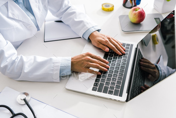 cropped view of doctor typing on laptop with blank screen / Photodune, Misc