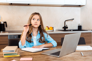 selective focus of pensive kid holding pen near notebook and laptop while e-learning at home / Photodune, Misc