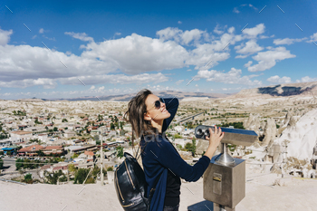 female tourist looking at city through binocular viewer, Cappadocia, Turkey / Photodune, Misc