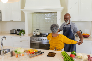 Senior african american couple dancing together in kitchen smiling / Photodune, Misc