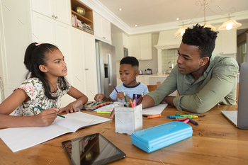 Happy african american father with daughter and son doing homework at home smiling / Photodune, Misc