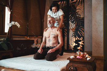 Smiling lean tatooed male enjoying thai massage / Photodune, Misc