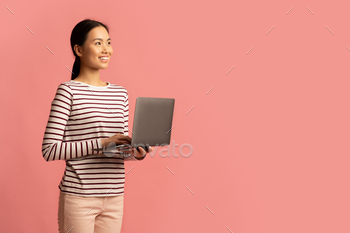  Female With Laptop Computer Standing Over Pink Background And Looking Aside At Copy Space, Smiling Korean Female Enjoying Distance Learning