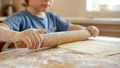 Closeup of little boy with rolling pin making dough and cooking on domestic kitchen - PhotoDune Item for Sale