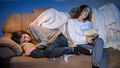 Young friends fell asleep while watching TV show on sofa at night - PhotoDune Item for Sale