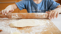 Closeup of little boy rolling dough with rolling pin for making pizza - PhotoDune Item for Sale