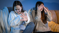 Two girls watching scary or bad TV show and feeling disgusting - PhotoDune Item for Sale