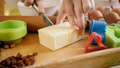 Closeup of woman cutting butter for cooking pie or cake - PhotoDune Item for Sale
