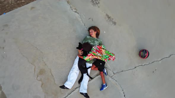 a White Woman with Her Latin American Son and Dog is Lying on the Floor and Smiling Shooting From a