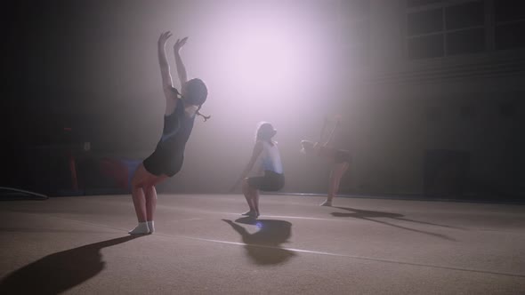 Group of Junior Female Gymnasts are Performing Backflip in Sports Hall Training Floor Exercises Slow
