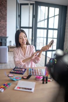 Beauty blogger trying her new blusher while doing makeup / Photodune, Misc