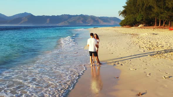 Teenage lovers tan on relaxing sea view beach journey by shallow water and white sandy background of